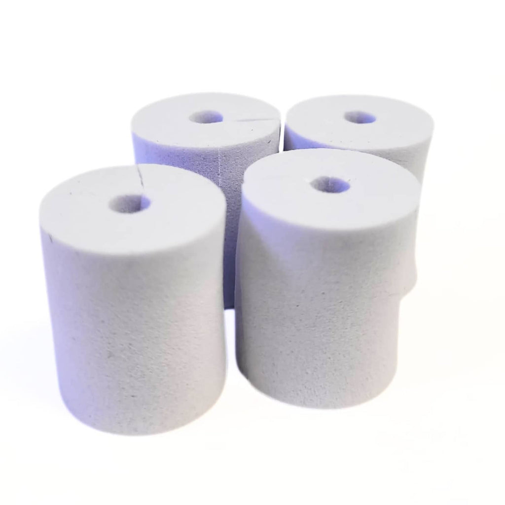 White/gray foam damping inserts with center holes, four cylindrical pieces
