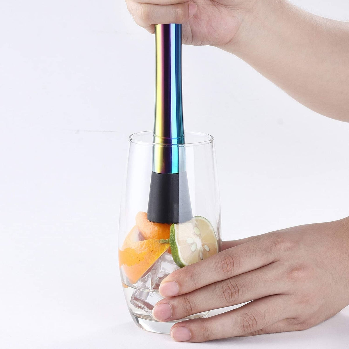 Cocktail muddler held over a glass with ice and citrus slices