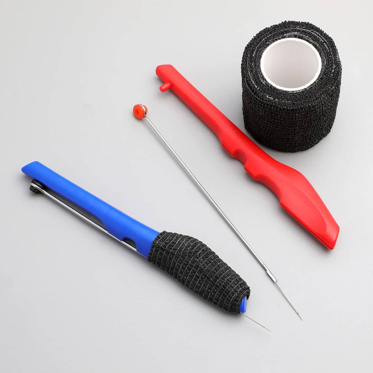 Two tattoo poke-a-stick tools with red and blue handles and black grip tape wraps