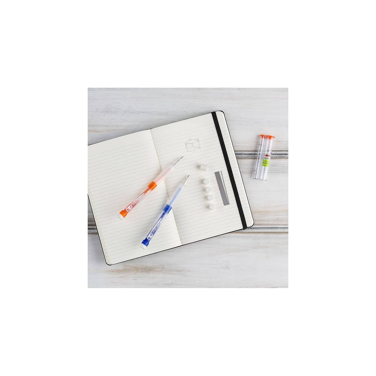Two Velocity Max mechanical pencils, orange and green, on open notebook