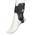 Black rigid ankle brace with open heel and adjustable strap on bare foot