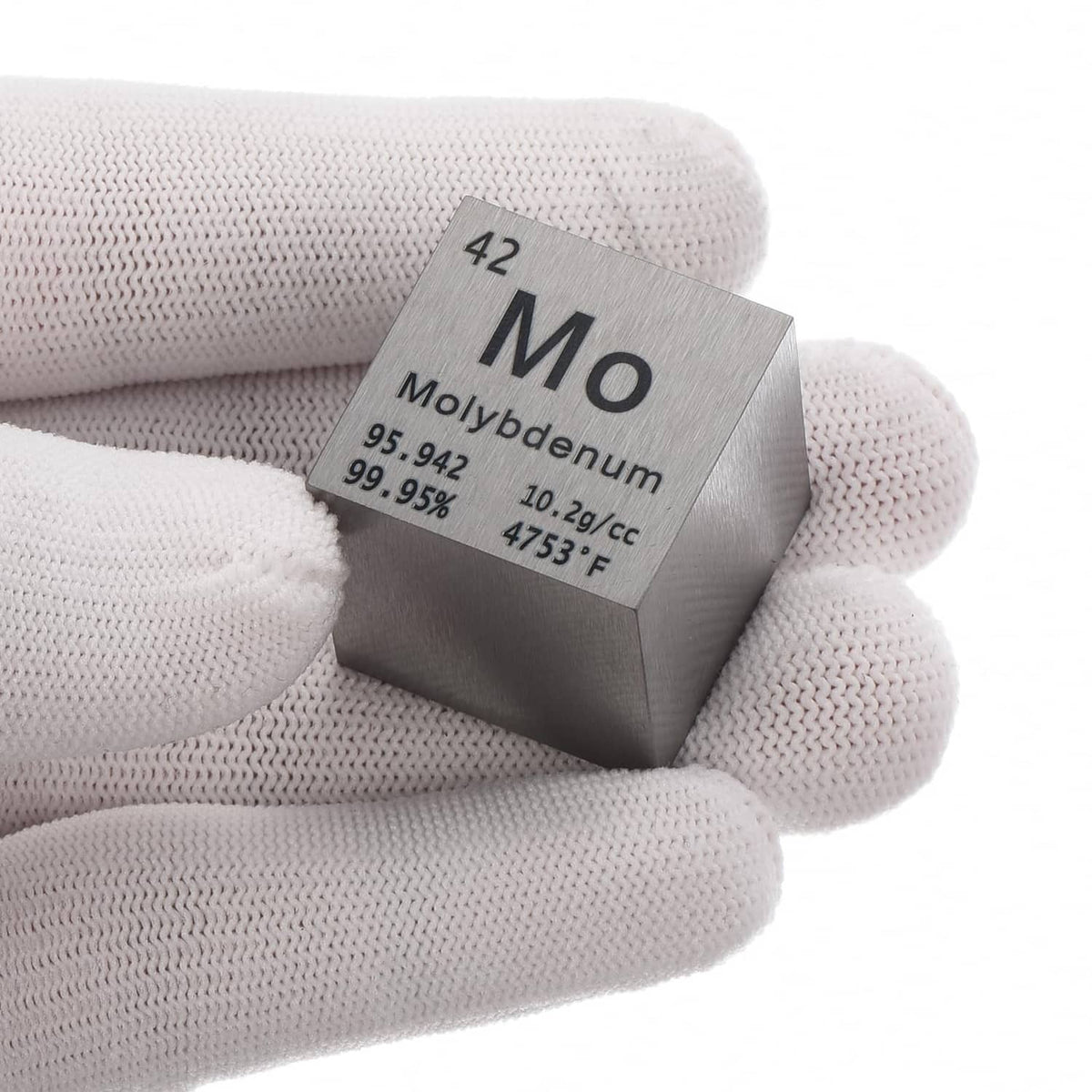 Molybdenum metal cube marked Mo on side, held in light gray knit gloves