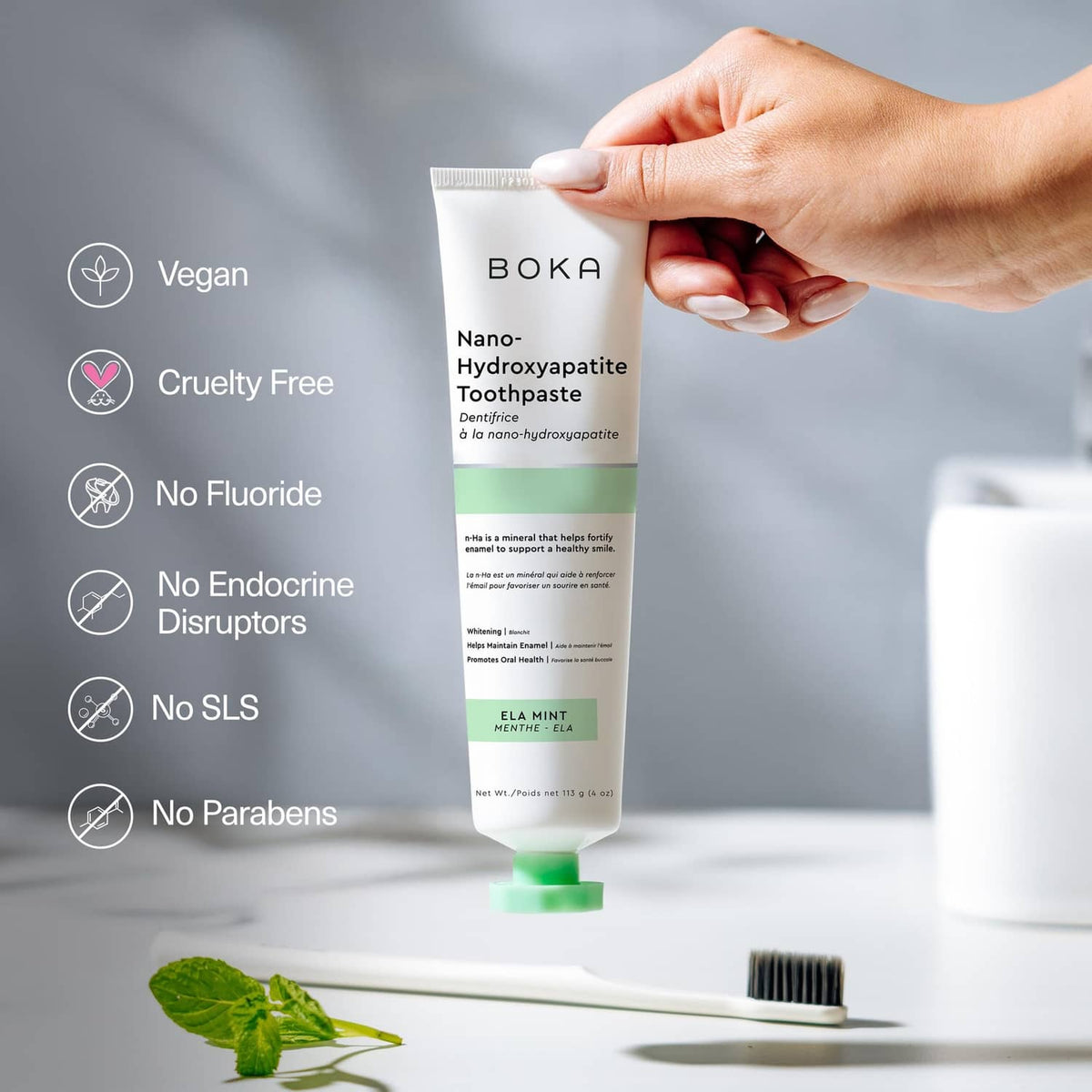 Fluoride-free nano-hydroxyapatite toothpaste tube held in hand, mint ELA mint, green cap