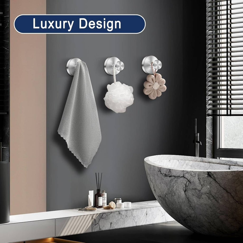 Silver suction cup hooks with towels and bath accessories on wall