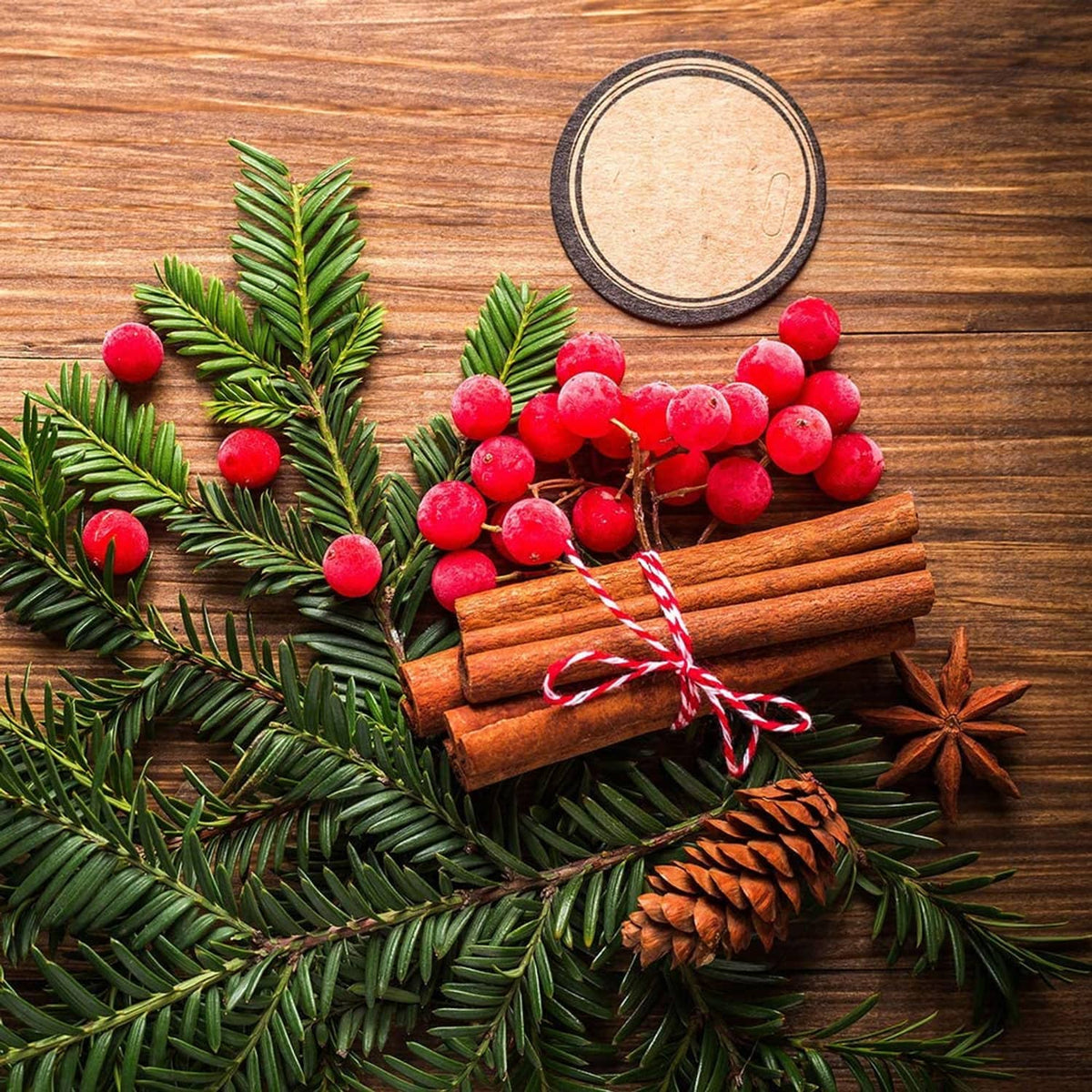 Red and white twine wrapped on Christmas greenery with cinnamon sticks and berries