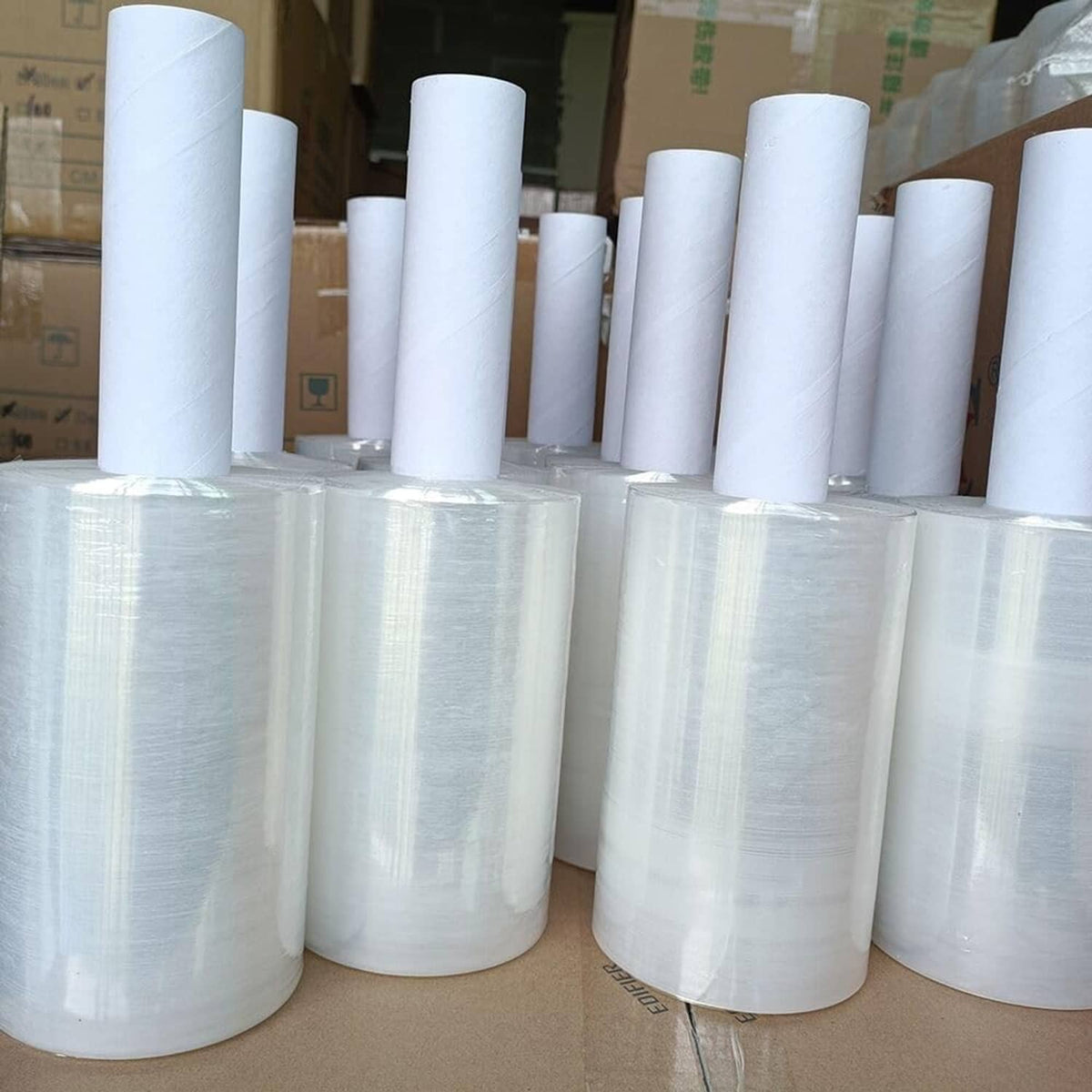 Clear stretch wrap plastic rolls with white cores, stacked together