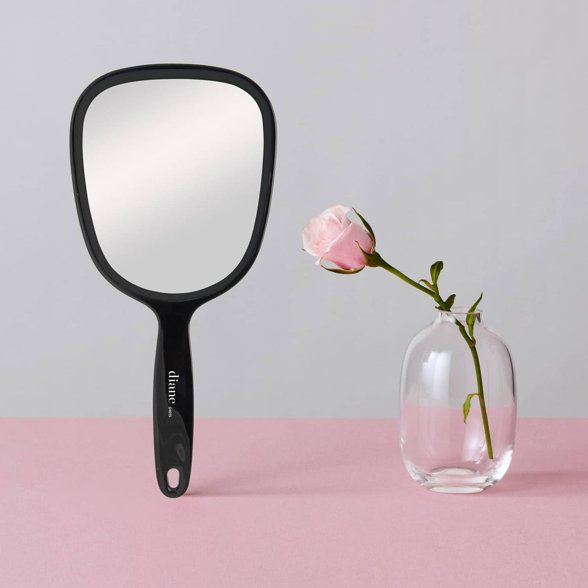 Black single-sided handheld magnifying mirror with glossy oval frame and grip handle