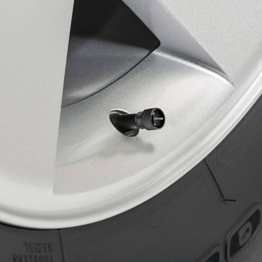 Black tire valve stem cap on car wheel rim, textured metal with ZR2 logo