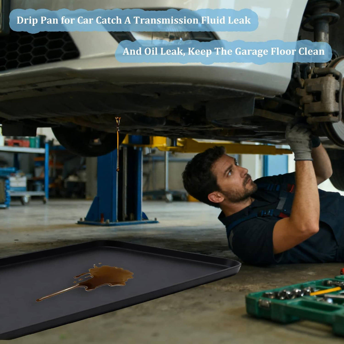 Black under-car drip pan catching brown fluid leak in auto repair bay
