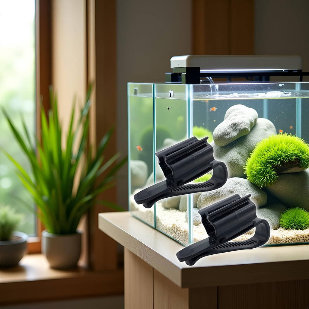 Two black hose mounting clips on tank glass with curved clamps and ridged grip