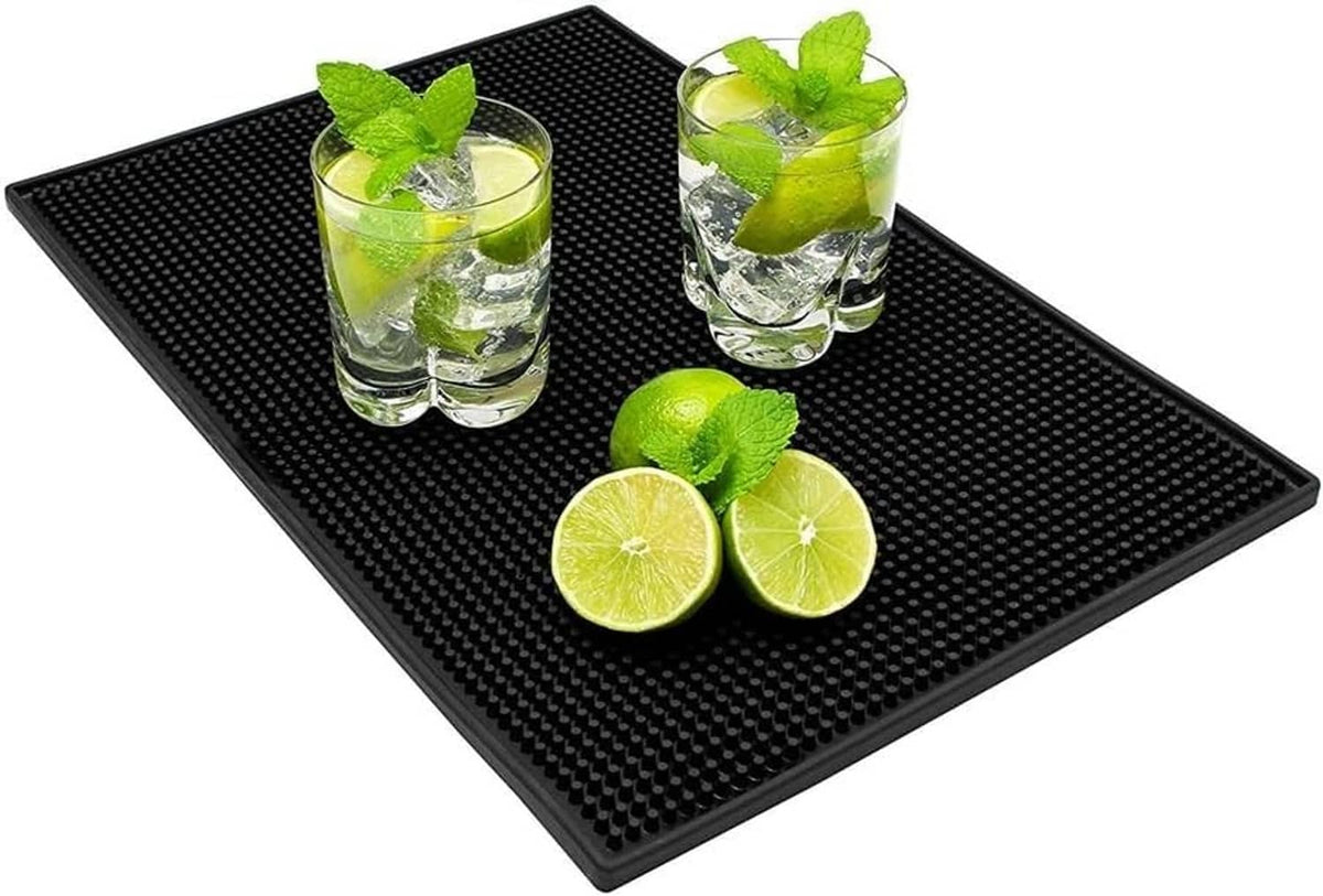 Black rubber bar mat with raised dot texture holding glasses and lime slices