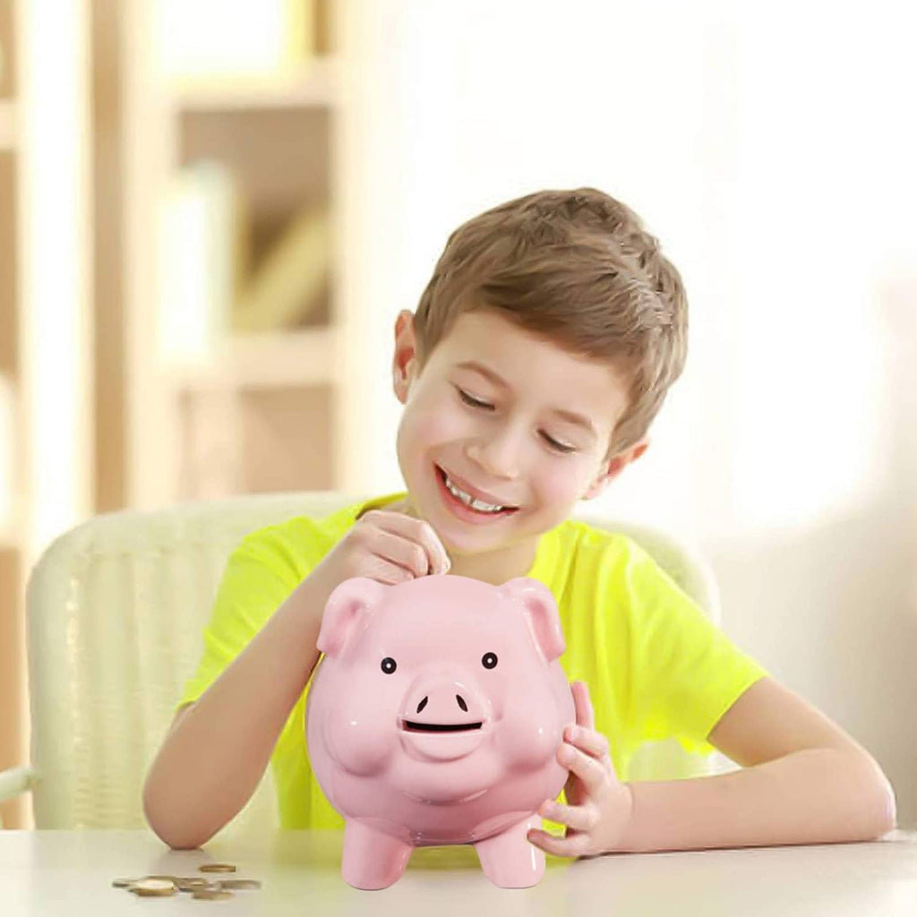 Pink ceramic piggy bank on tabletop, smiling face and upright ears