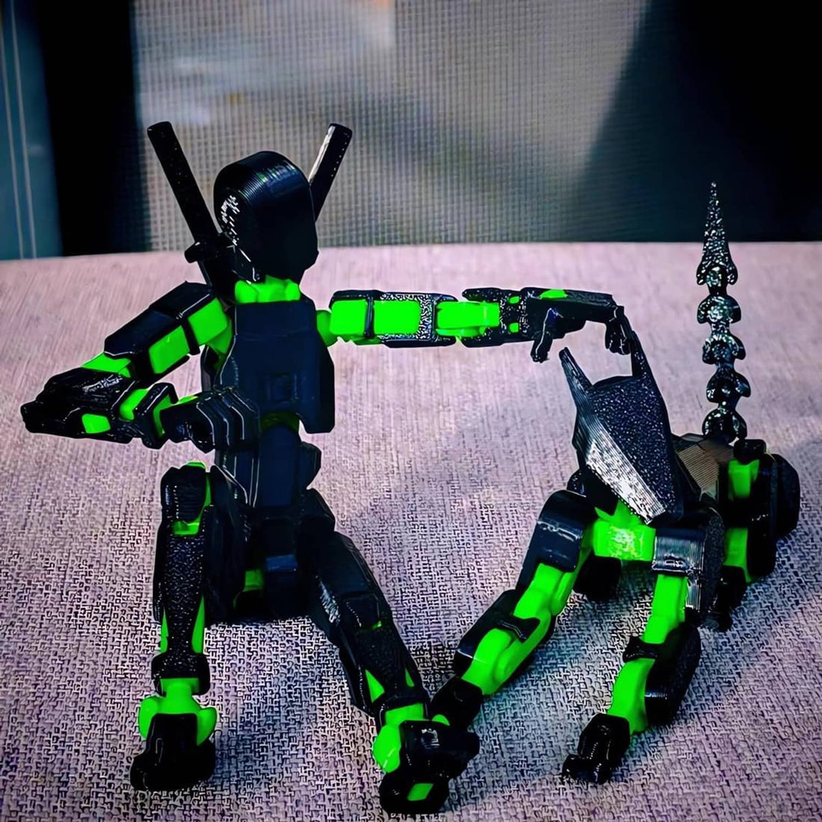 Two dark-and-green robot action figures posed on a tabletop, with sword accessories