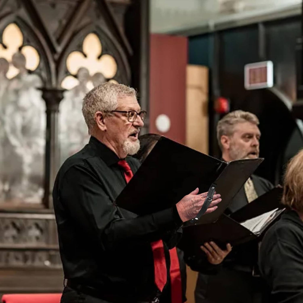 Black choir music folder held by singer during performance