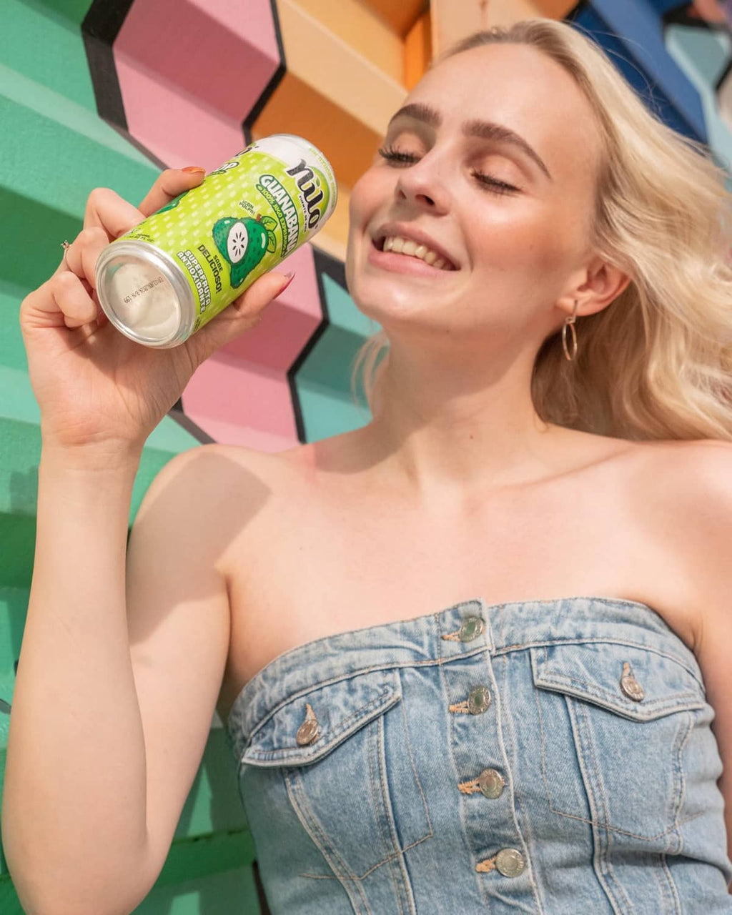 NILO soursop juice can held by smiling woman, close-up on drink can