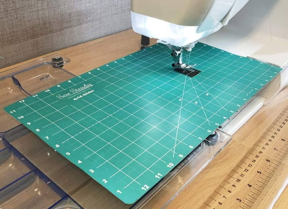 Green quilting frame mat with white grid markings for free-motion quilting