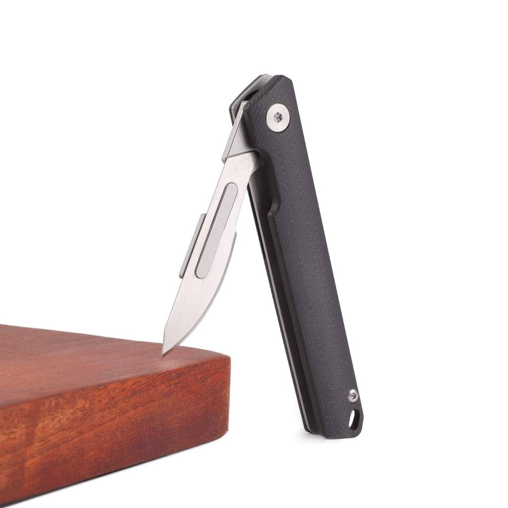 Slim folding pocket knife with black textured handle and open silver blade on stand