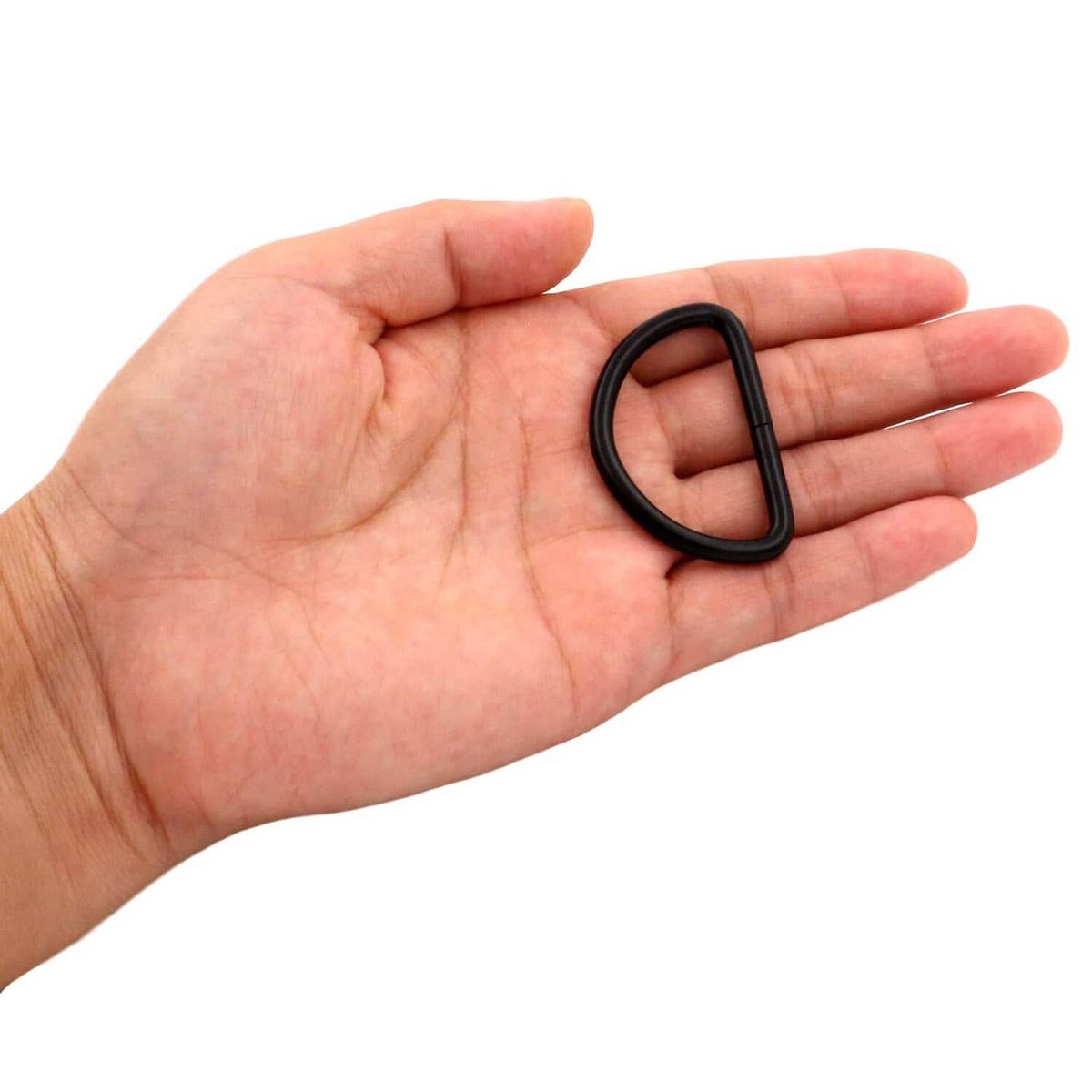 Black D-ring buckle held in hand, non-welded U-shaped metal loop for webbing