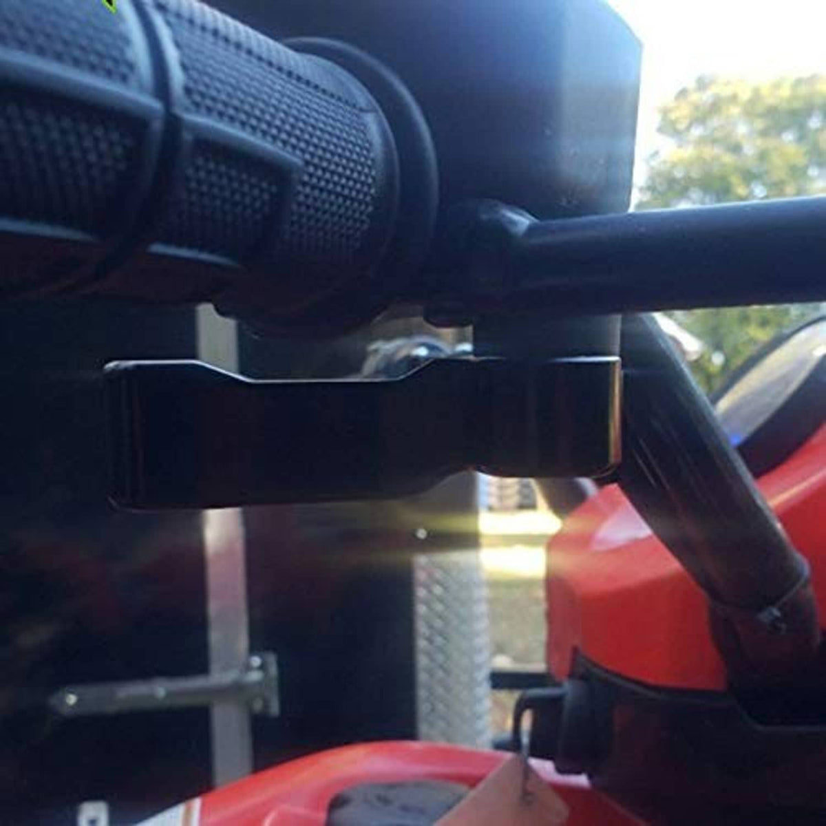 Installed black thumb throttle lever on ATV handlebar, close-up of lever and bolt