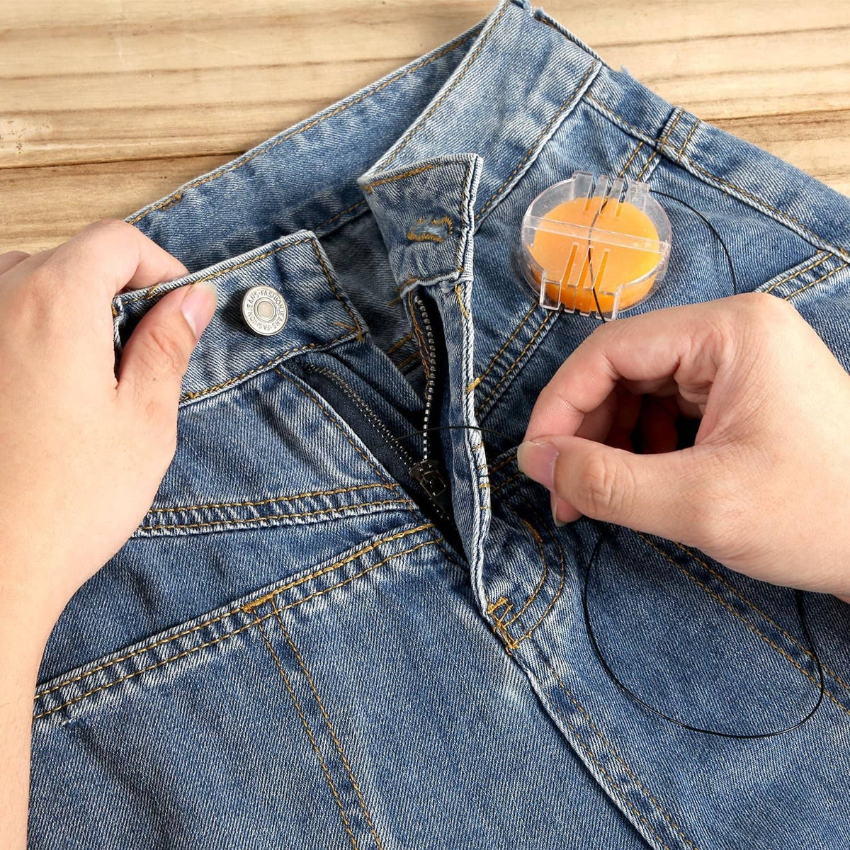 Orange beeswax thread conditioner disc in clear holder on blue denim