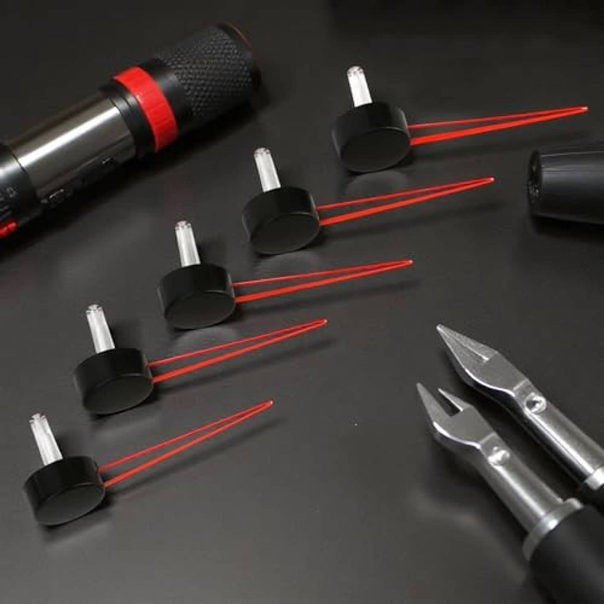 Speedometer needle set with black bases, red pointer arms, and white tips.