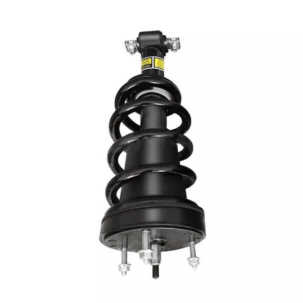 Front shock strut with black coil spring and yellow safety label on damper