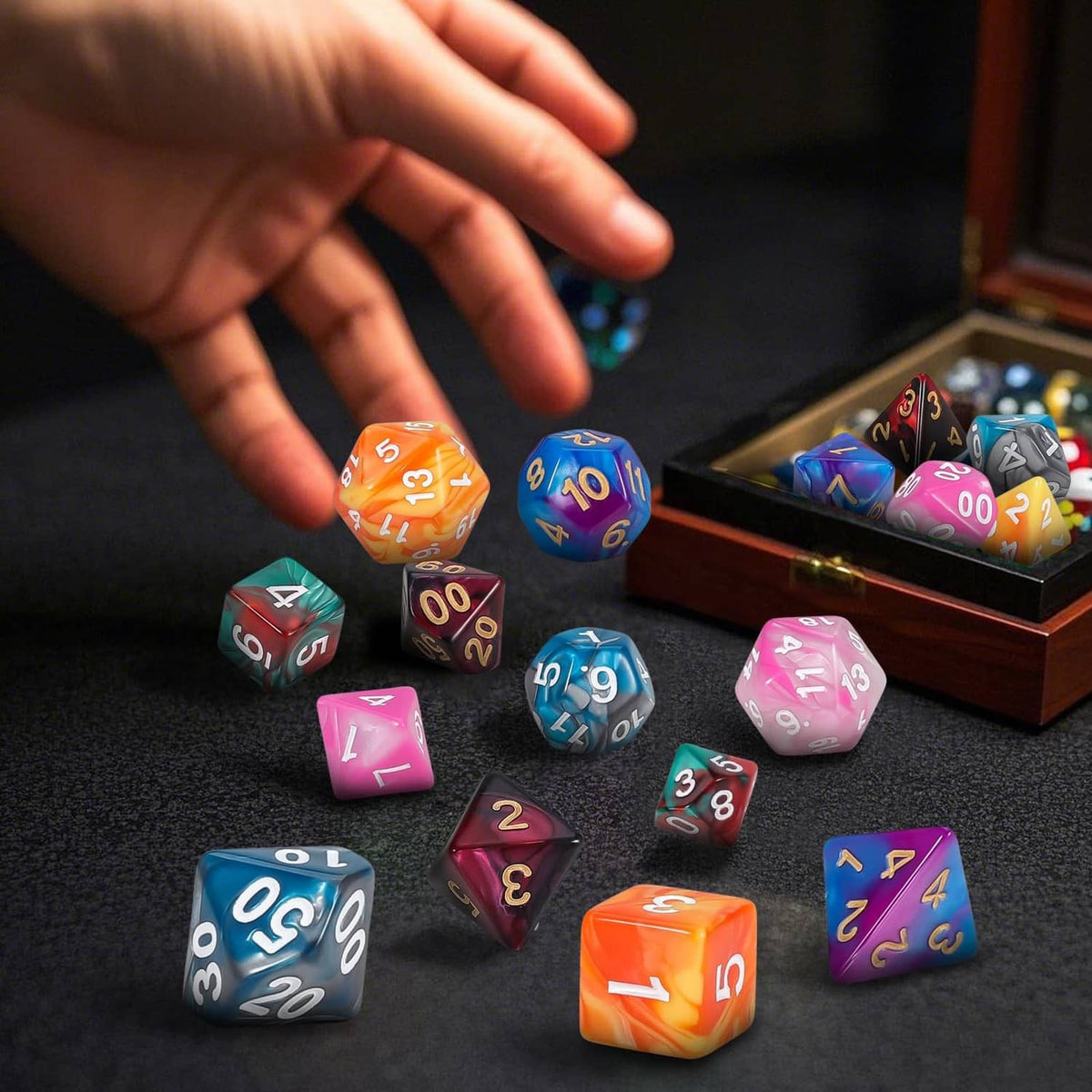 Polyhedral RPG dice scattered on a table with a hand reaching toward them
