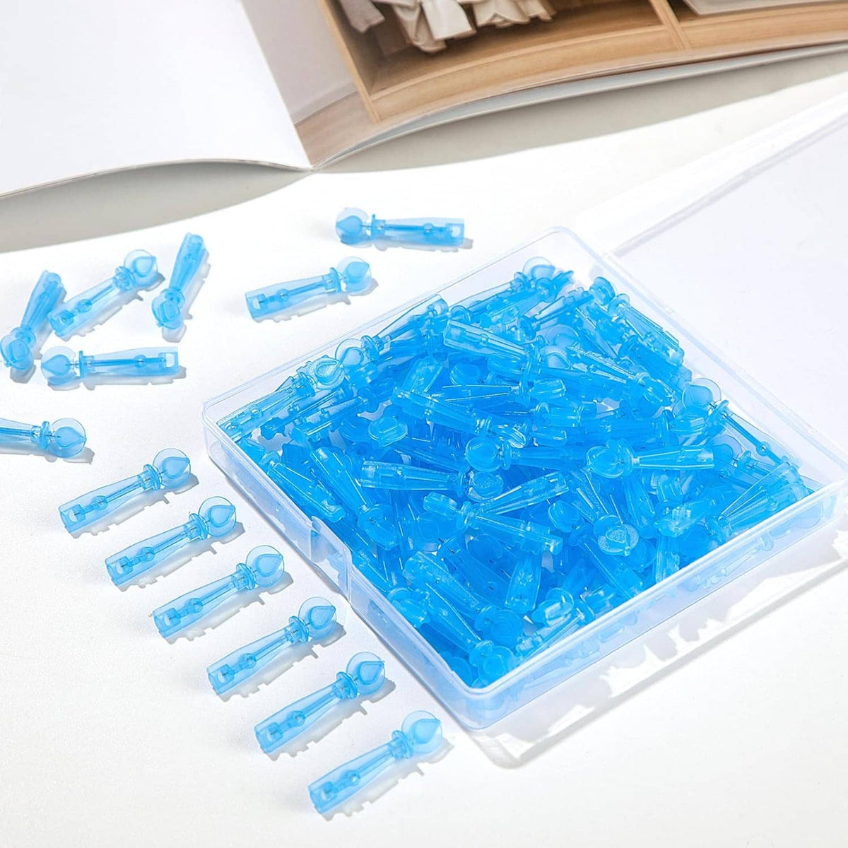 Disposable acne lancets laid in a clear tray with multiple blue devices