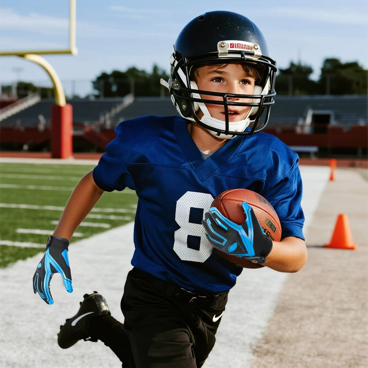 Black and blue youth receiver gloves holding a football with silicone-style dotted grip