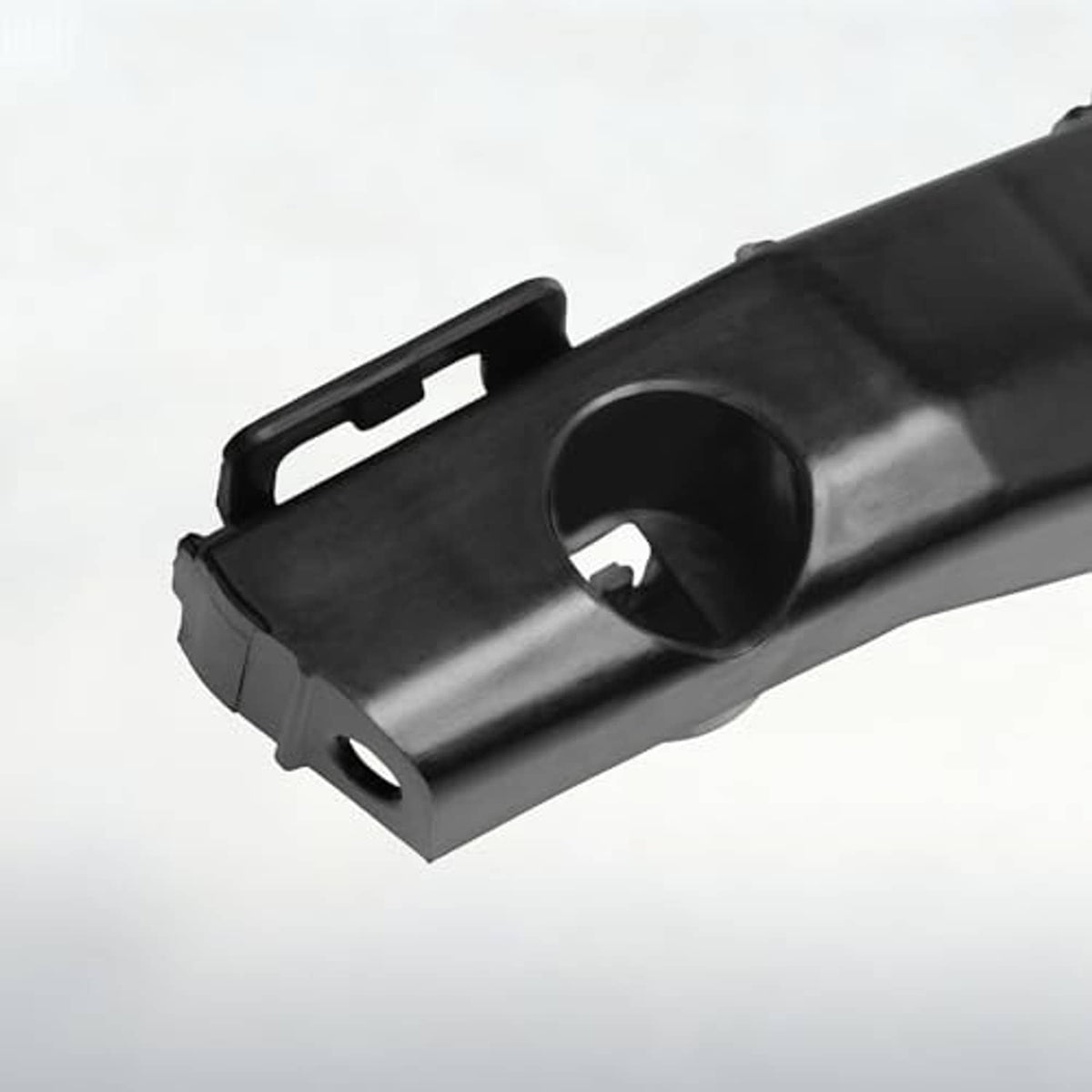 Close-up of dark gray front bumper bracket end with circular opening and tabs