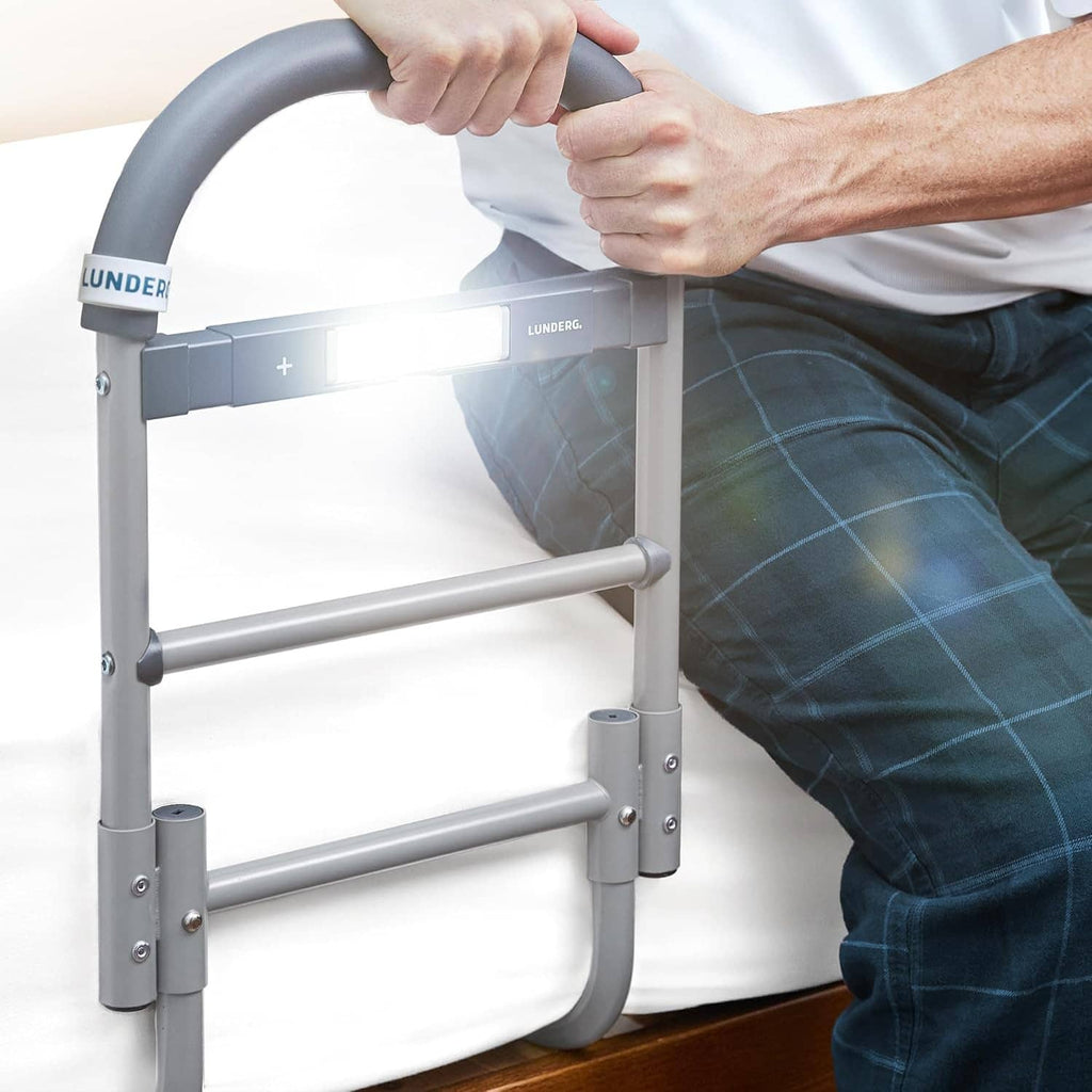 Grey metal bed assist rail with curved grab handle and glowing motion light