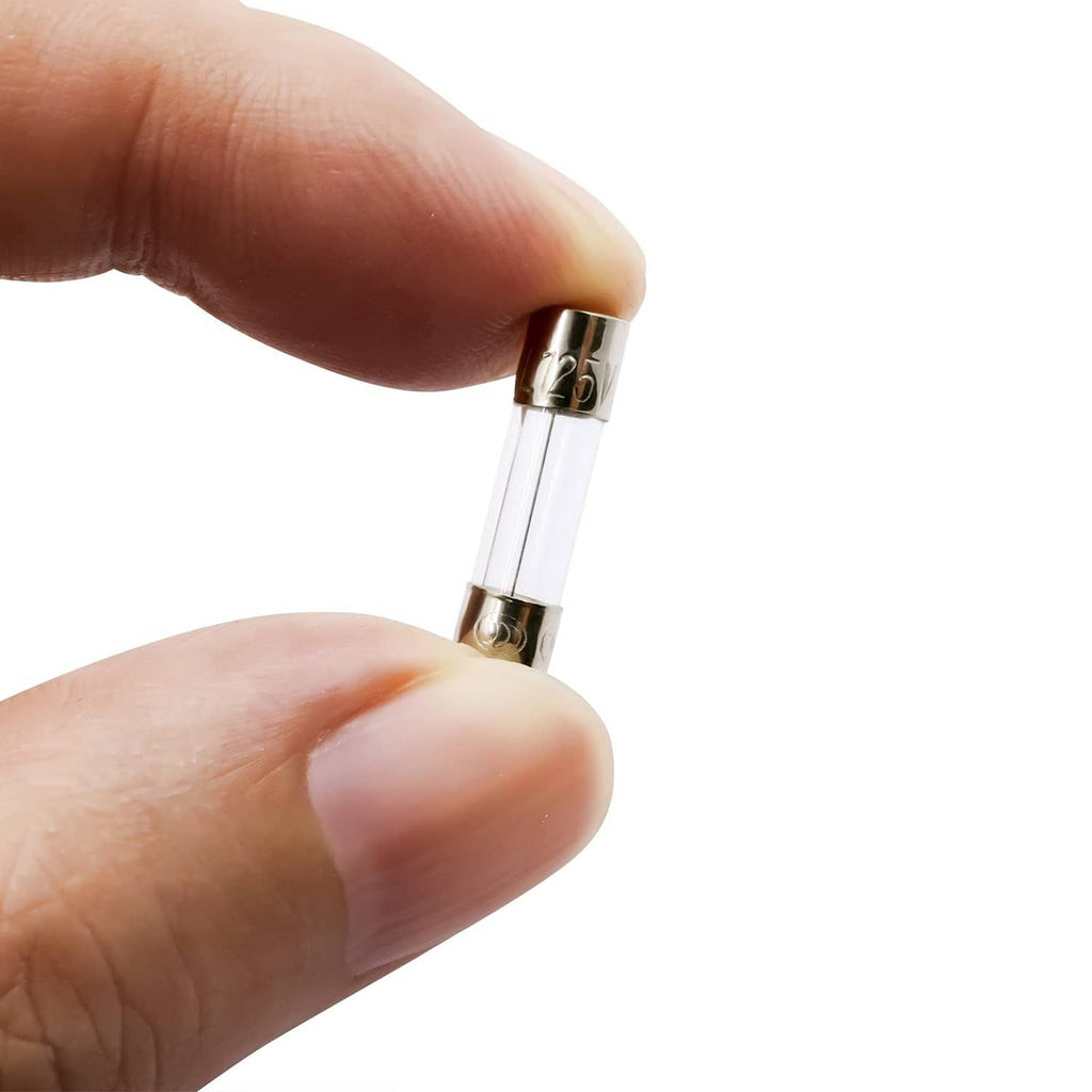 Hand holding a glass fast-blow fuse with metal end cap