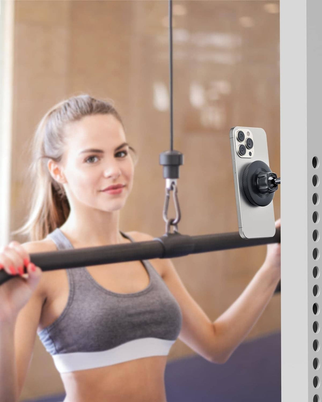 Black magnetic phone holder attached to gym equipment holding a phone in portrait