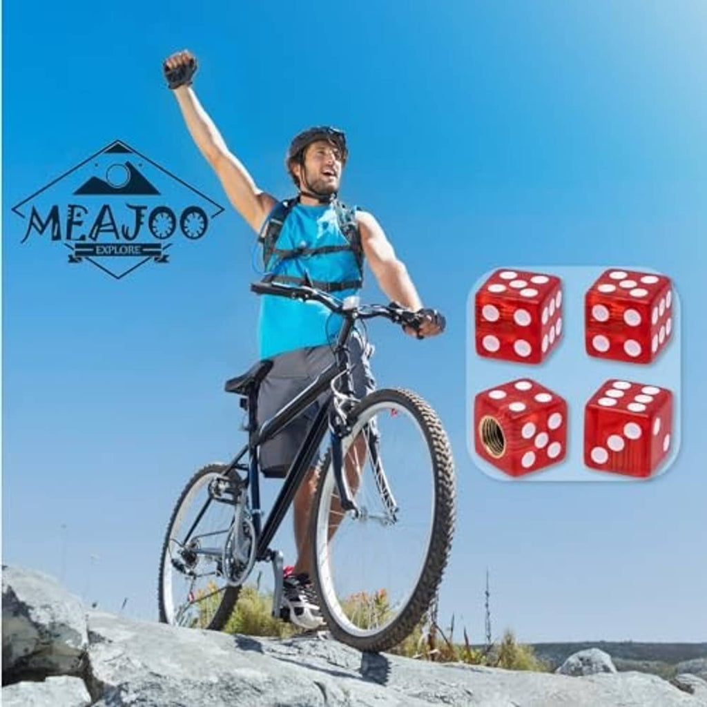 Red dice-shaped tire valve stem caps set displayed near a bicycle on outdoor ride