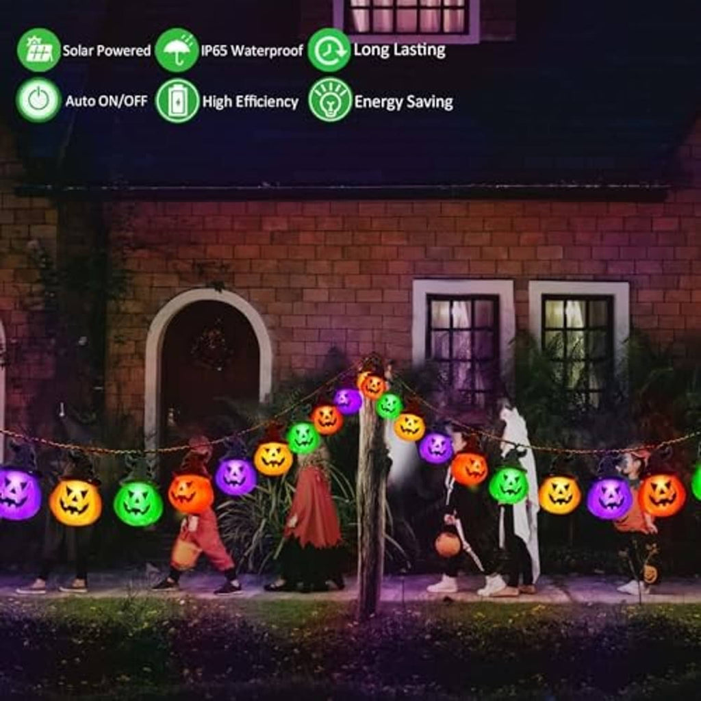 Solar pumpkin string lights with glowing jack-o'-lantern bulbs in orange, green, and purple along a walkway.