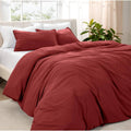 Red duvet cover set with two matching pillow shams on a bed
