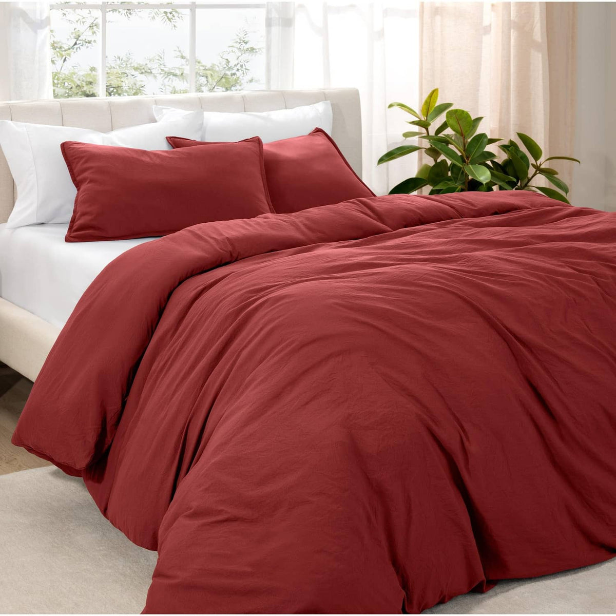 Red duvet cover set with two matching pillow shams on a bed