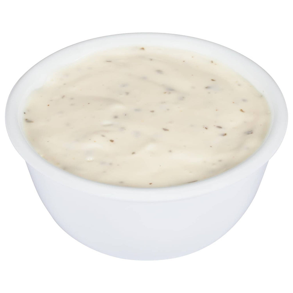 Small cup of creamy ranch dressing with visible seasoning specks