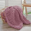 Chunky knit throw blanket, burnt rose, thick looped texture, draped with soft fold