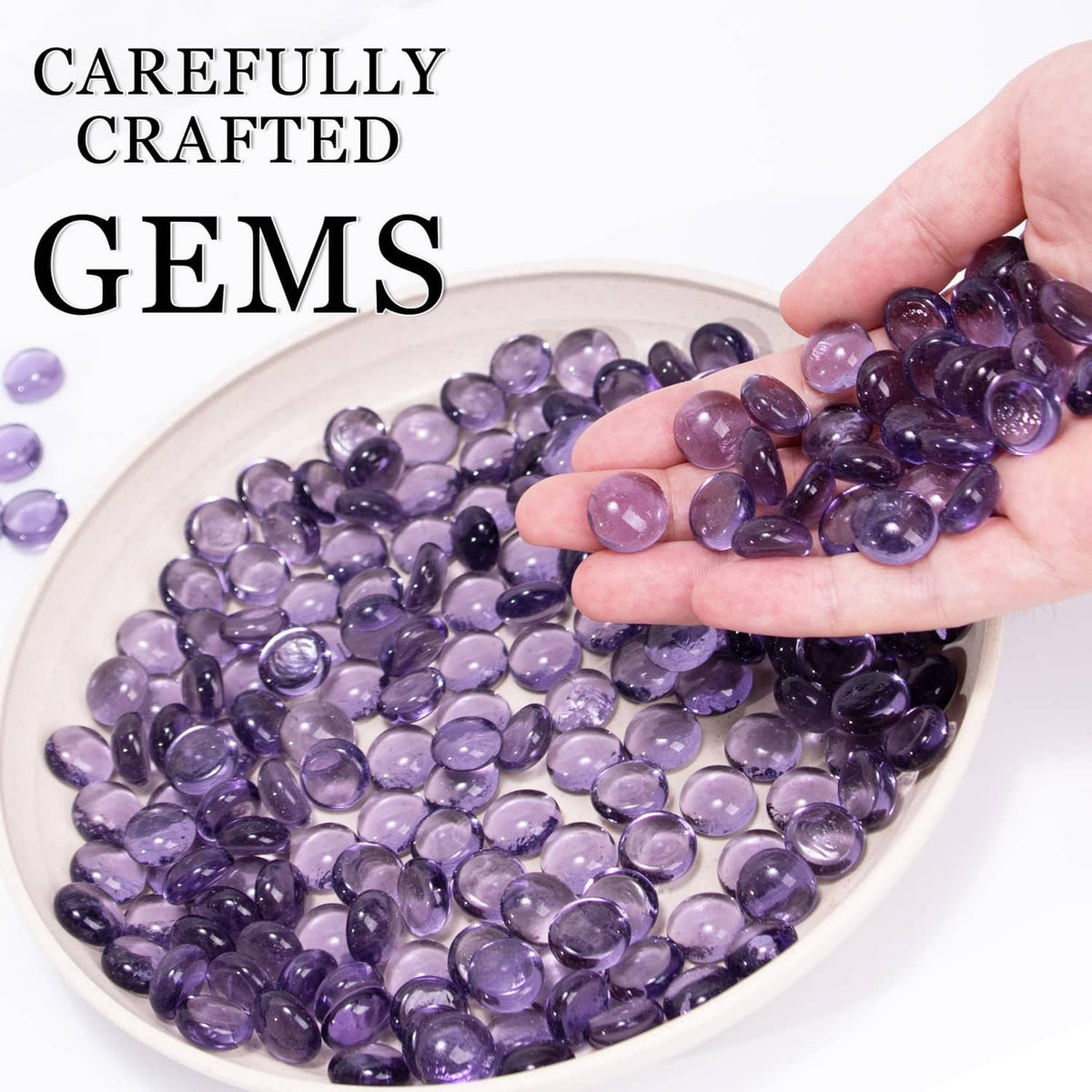 Purple glass gems in assorted round shapes, shown pouring into a bowl
