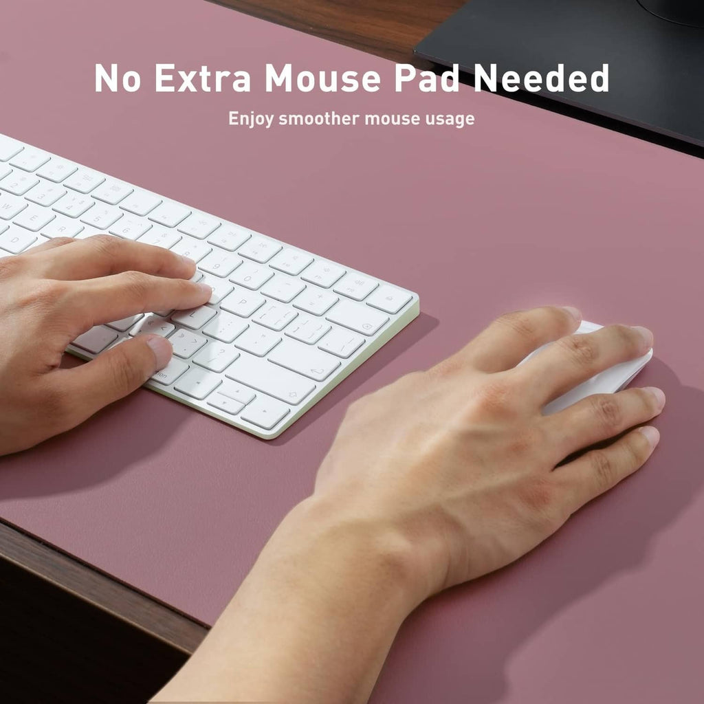 Dark pink desk pad with hands smoothing out a wrinkle-free surface beside keyboard