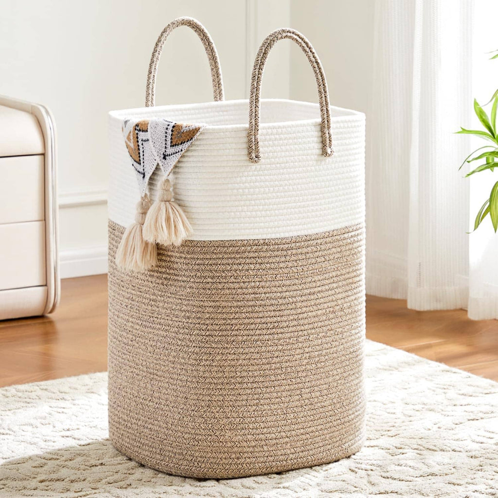 Two-tone woven cotton rope laundry hamper with curved handles and tassel front detail.