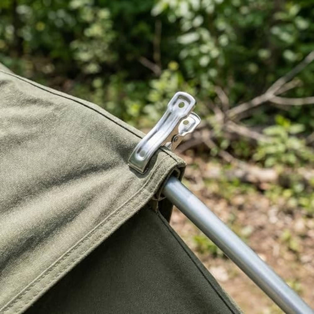 Stainless steel clamp securing green fabric over a metal pole outdoors