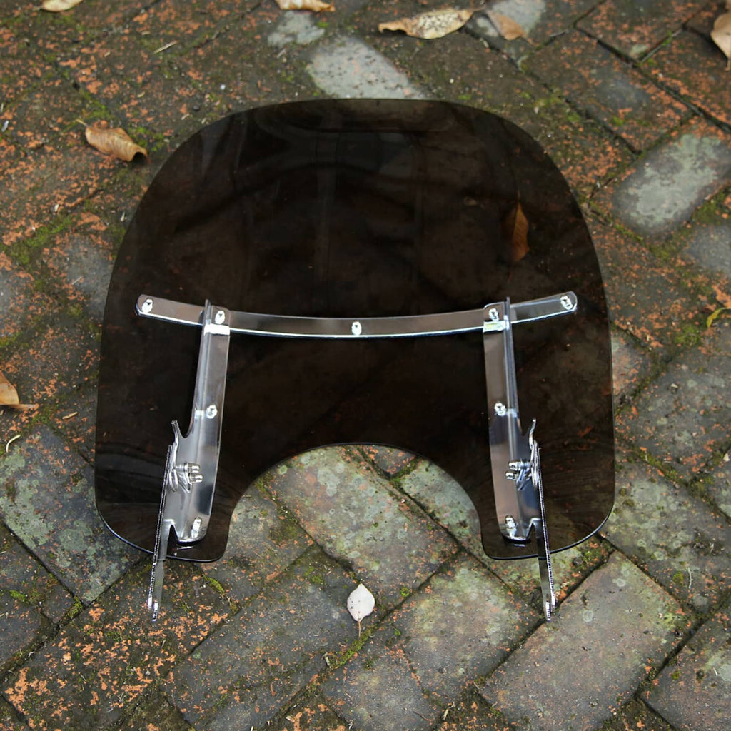 Black-tinted motorcycle windshield with silver frame brackets and two lower supports