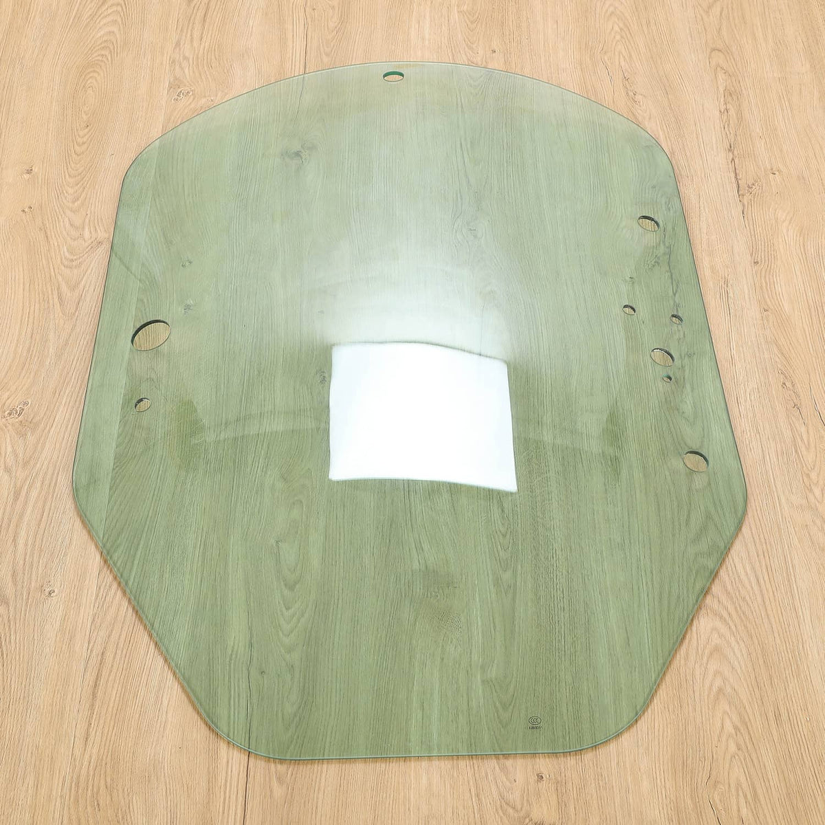 Green cab door glass panel with mounting holes and reflective center area.