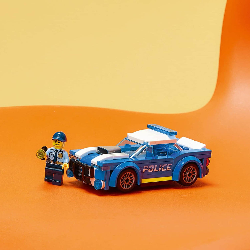 Blue police toy car with minifigure, white hood and yellow side stripe