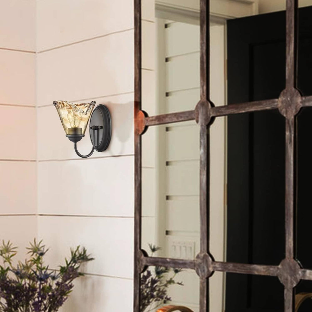 Vintage wall sconce with amber art glass shade on exterior-style wall panel