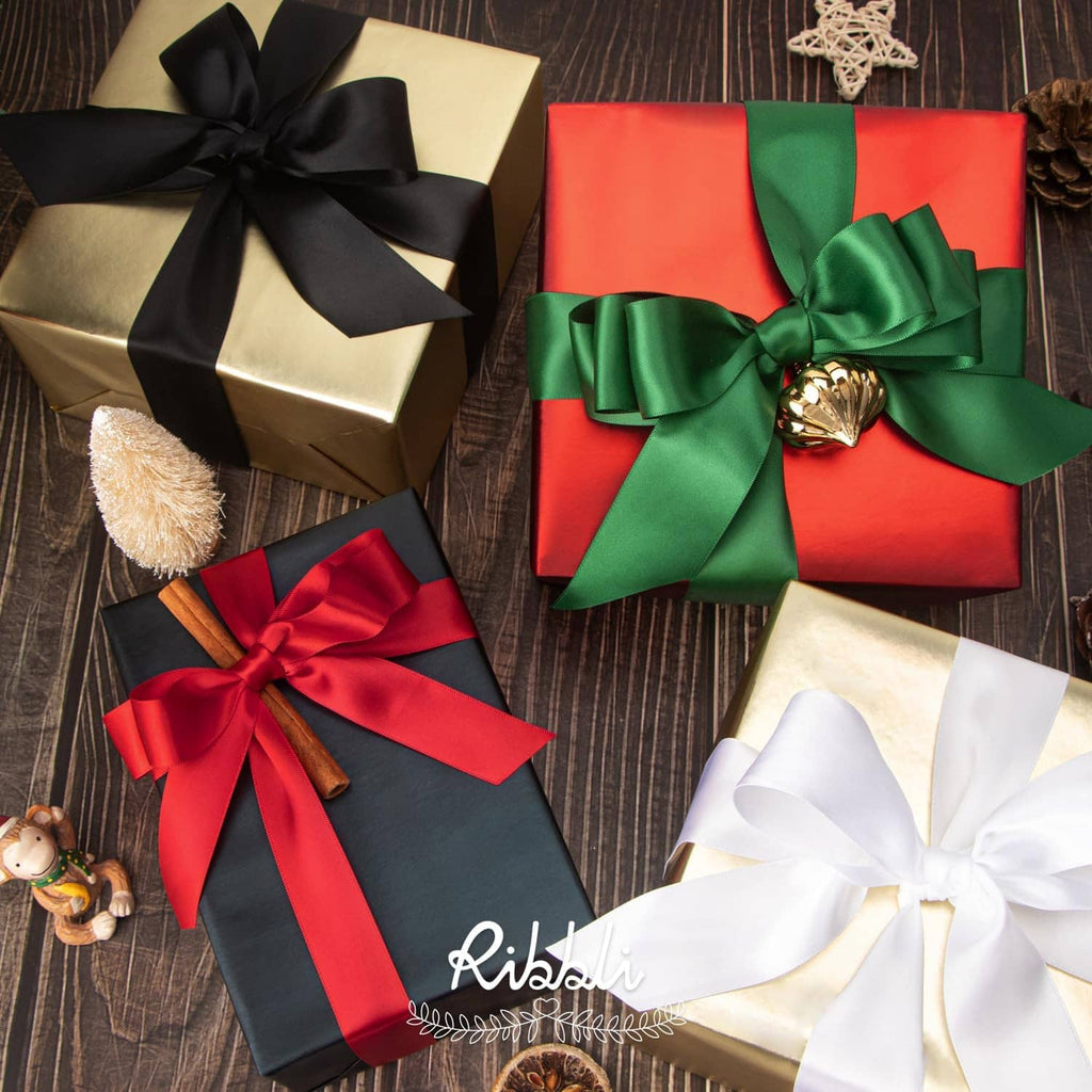 Red double-faced satin ribbon bows on gift boxes with curled ribbon ends