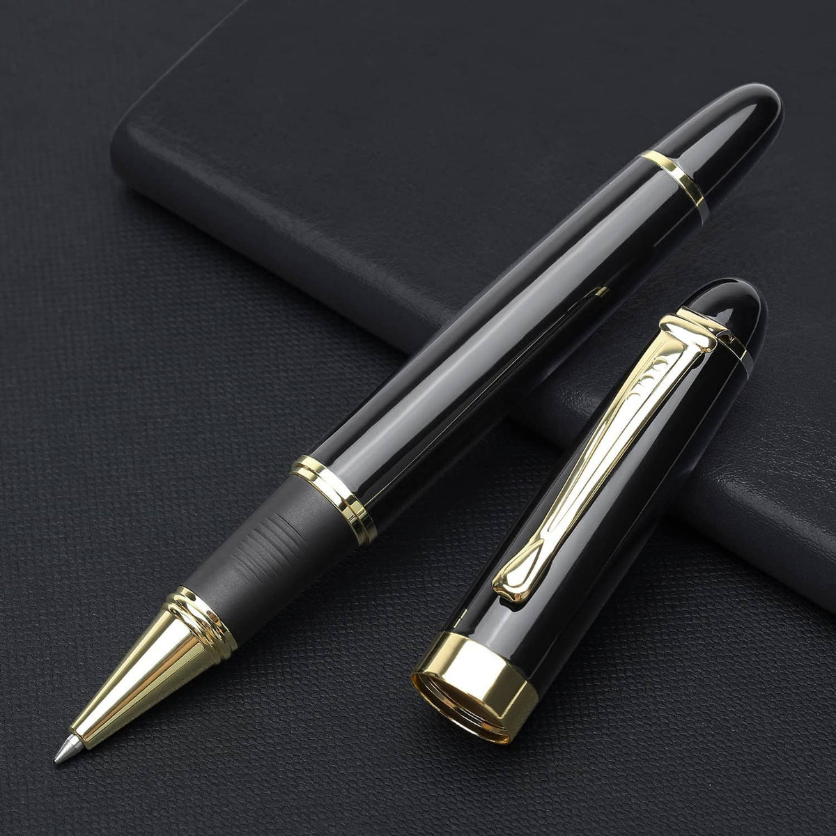 Black luxury ballpoint pen with gold cap and clip, lying on a case