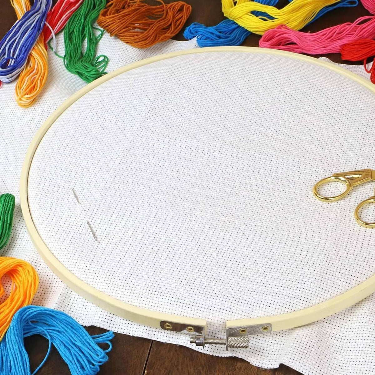 Bamboo embroidery hoop with white fabric and colorful embroidery floss around